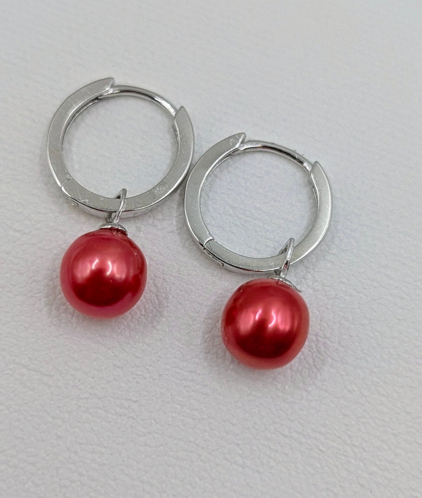 Silver Huggy earrings with deep coral pearls