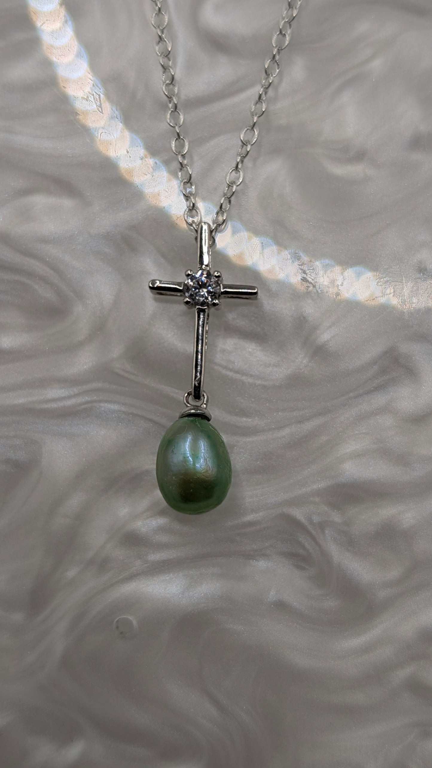 Silver cross with green pearl dangle