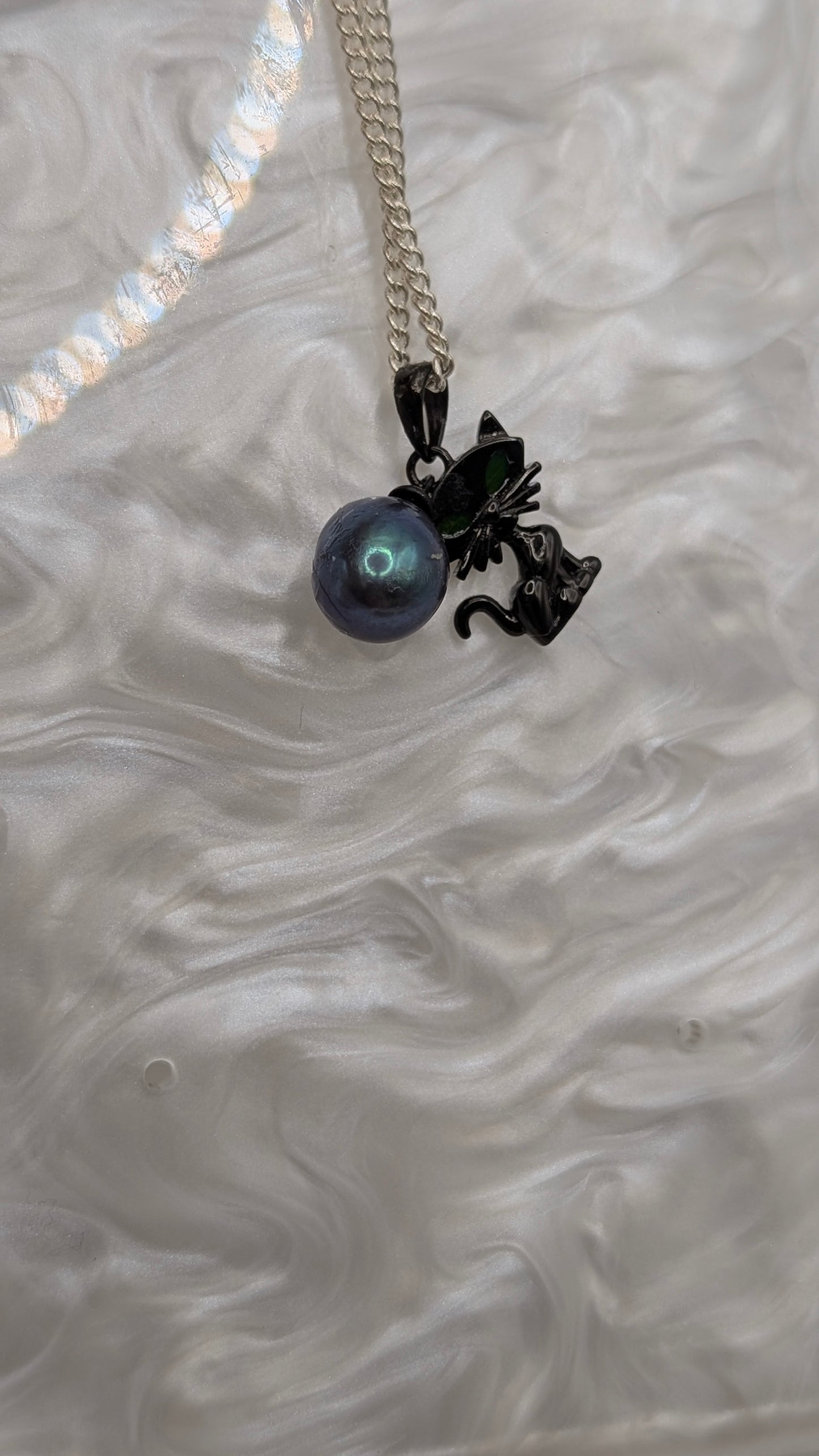 Black cat pendant with large green peacock rice