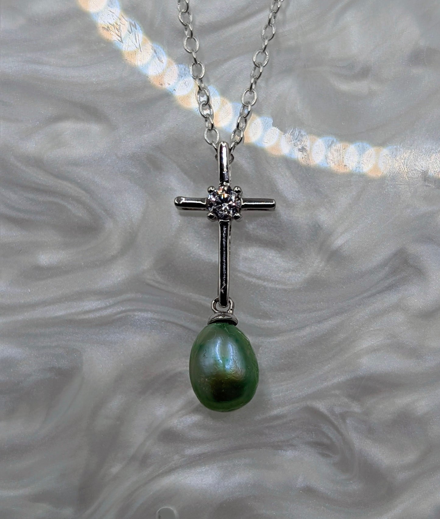 Silver cross with green pearl dangle