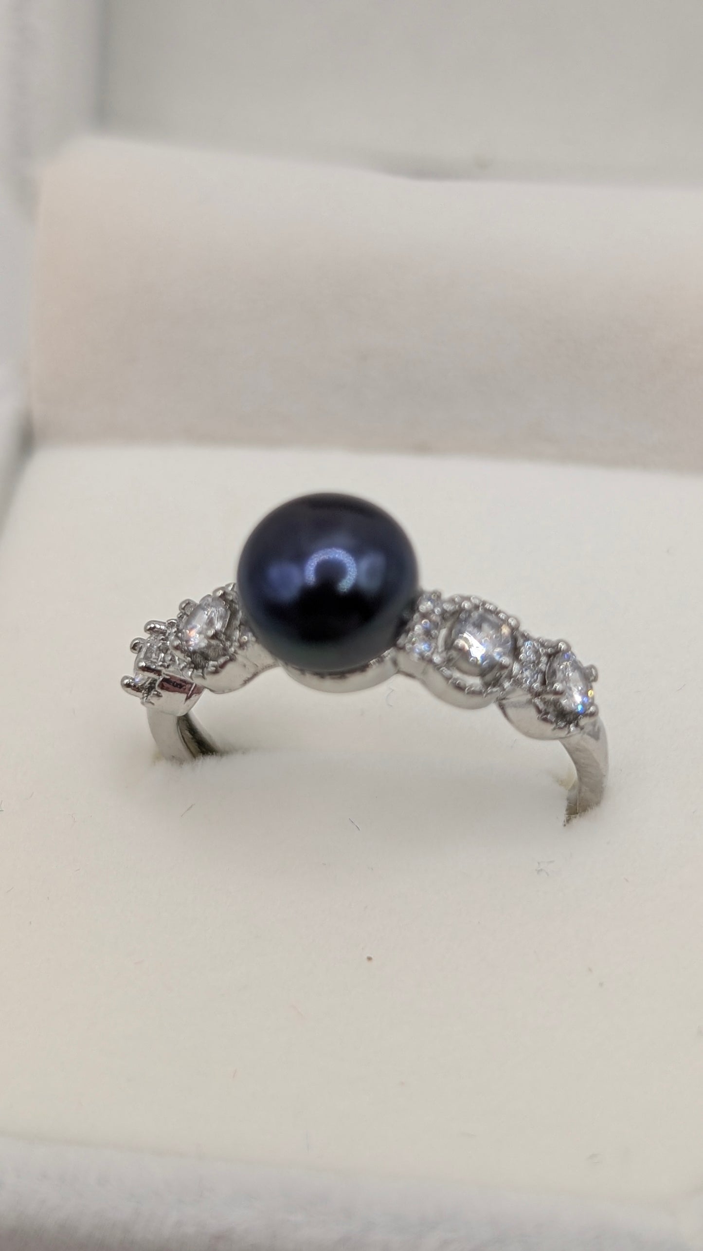 Black button pearl ring with zirconia accent stones
