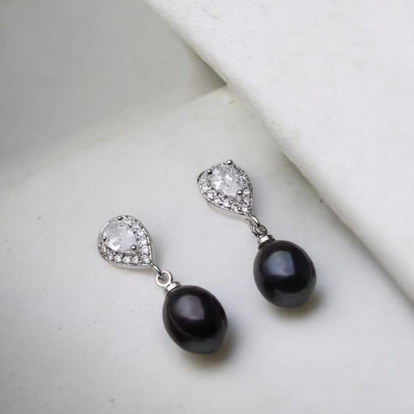 Oval stud earrings with black pearl drops