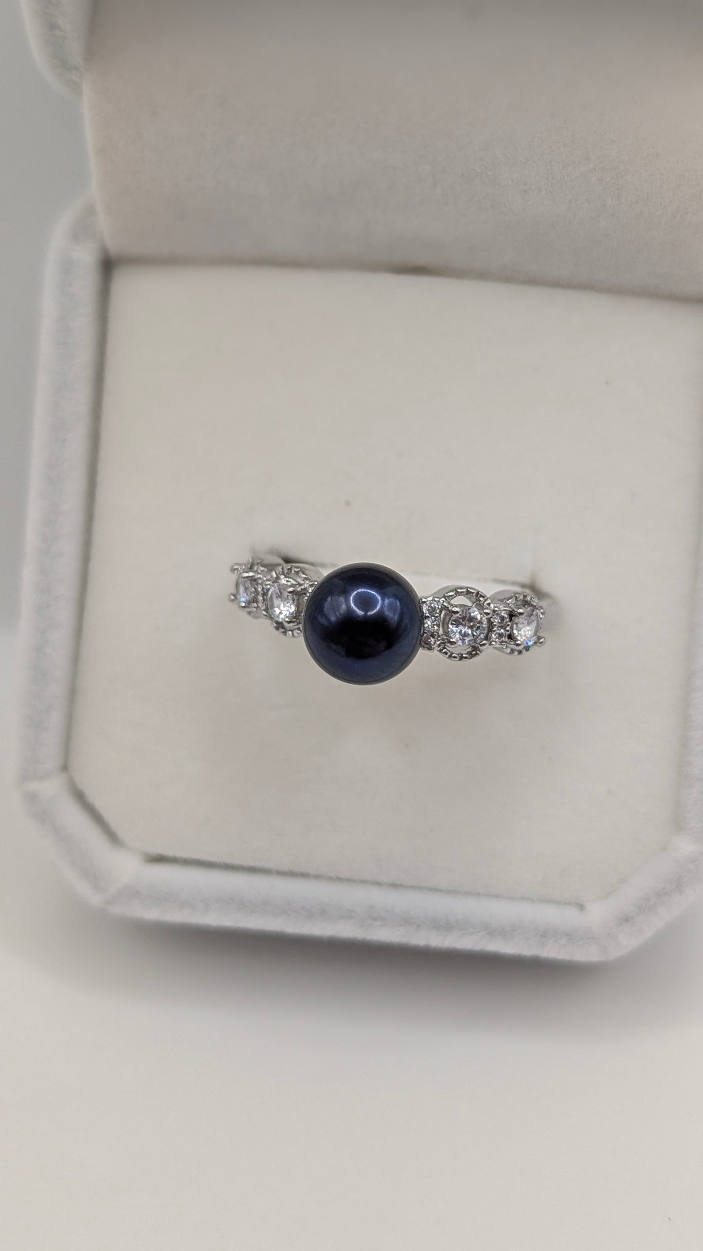 Black button pearl ring with zirconia accent stones